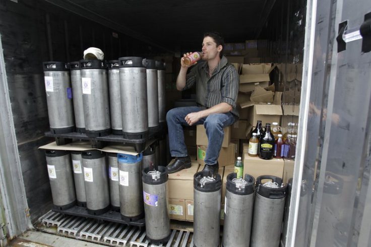 In this photo made July 1, 2010, Will Savitri, owner of Katalyst Kombucha fermented tea, takes a drink of tea from inside his refrigerated storage unit at the Katalyst Kombucha company in Greenfield, Mass. Regulators and retailers are concerned that the ancient and trendy tea may need to be regulated as an alcoholic drink. That’s because some bottles have more than 0.5 percent alcohol, the legal limit for a drink not to be considered alcoholic. (AP Photo/Charles Krupa)